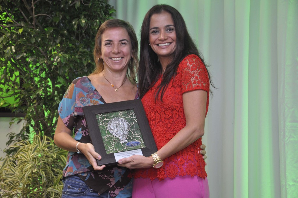 La educadora ambiental María Elena García de la organización Organización Pro Ambiente Sustentable, recibe una placa conmemorativa de parte de Lorraine Urdaz, gerente de Comunicaciones de Ford Puerto Rico.