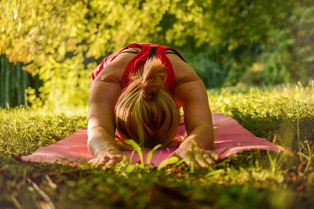 Mujer practicando yoga sobre la grama